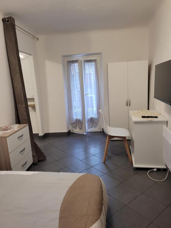 Dormitorio con cama, escritorio y TV en Appartement Moulinet, en Moulinet