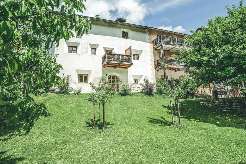 an exterior view of a house with trees in the yard at Il Maschun im historischen Engadinerhaus in Scuol