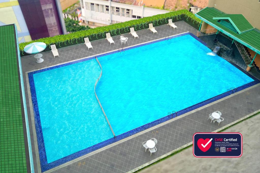 un modello di piscina con sedie e acqua di Tunjungan Hotel a Surabaya