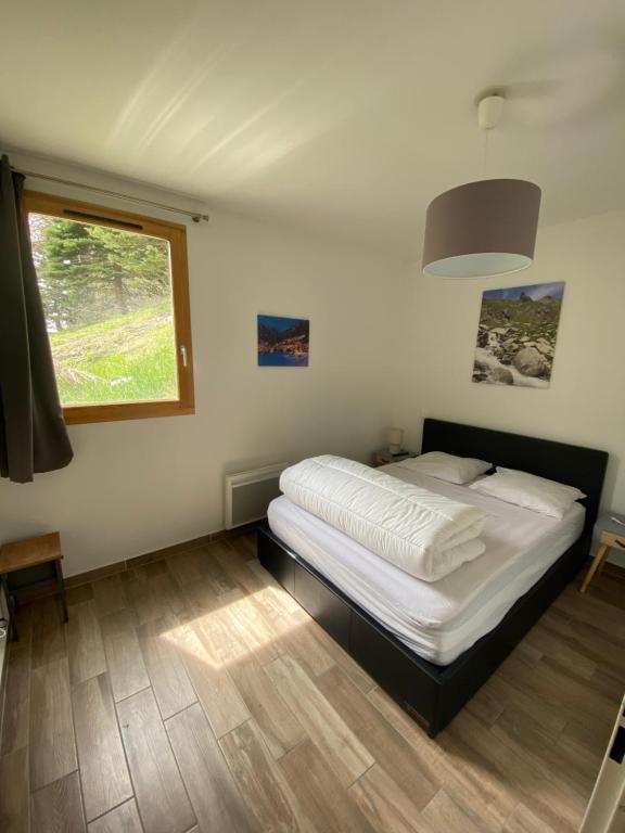 a bedroom with a bed and a window in it at Foux d Allos Centre de la Station 4 Pièces 8 Personnes in Allos