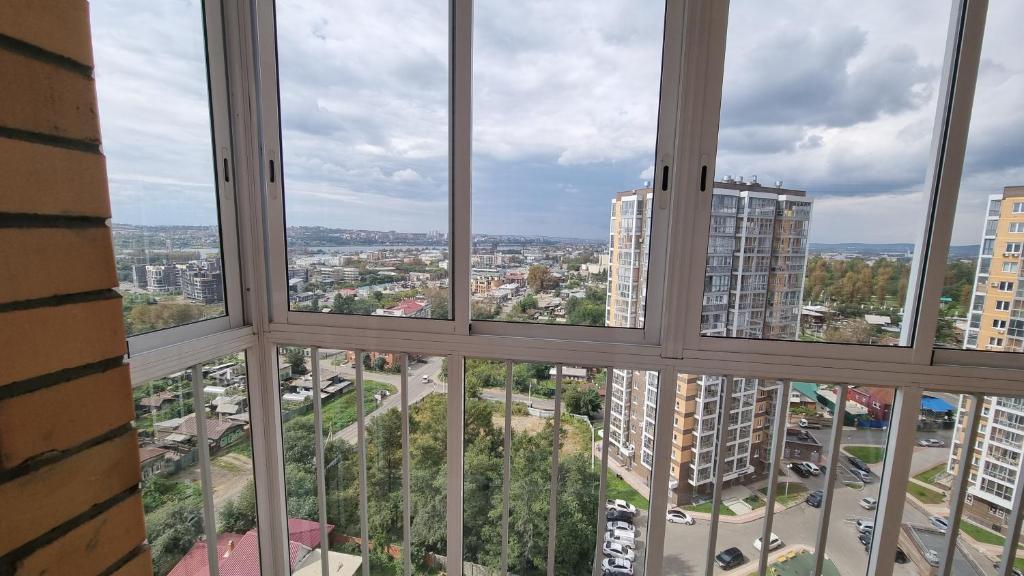 vistas a la ciudad desde la ventana de un edificio en Apart-Hotel Irkutskie Berega en Irkutsk