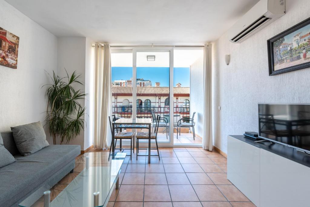 a living room with a couch and a table with chairs at Apartment Fuengirola City Station in Fuengirola