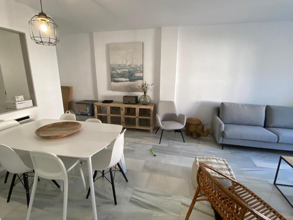 een woonkamer met een tafel en een bank bij Apartamento en Urbanización Mezquida Javea recién reformado in Jávea