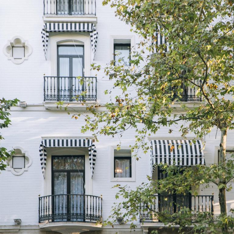 a white building with windows and balconies at Petit Palace Puerta de Triana in Seville