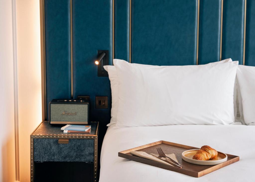 a bed with a tray with a plate of bread on it at Page8, Page Hotels in London