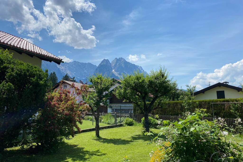 a yard with trees and mountains in the background at Haus mit wunderschönem Ausblick und Garten in Garmisch-Partenkirchen