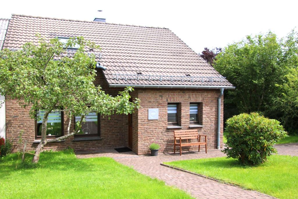 a brick house with a bench in front of it at Ferienhaus EifelNest in Scheid