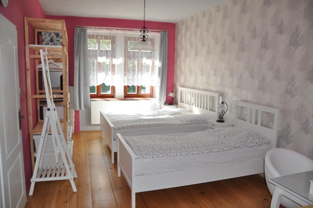two beds in a bedroom with a pink wall at Apartmán u Václava v centru města in Litomyšl