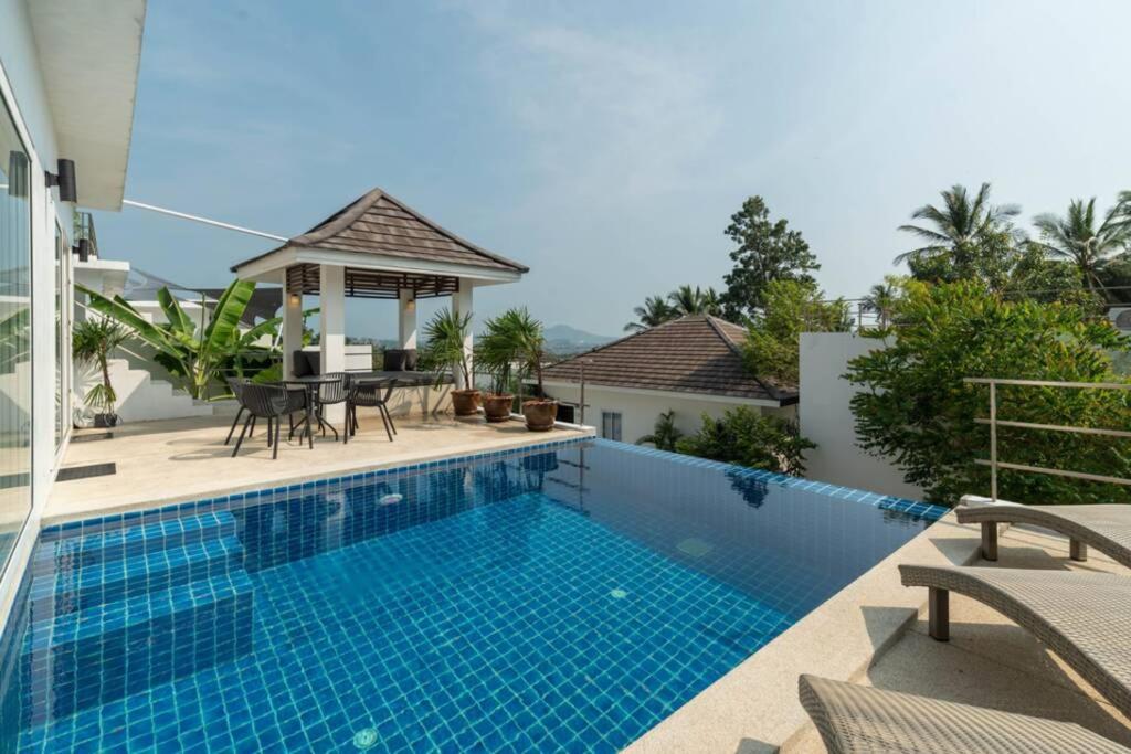 einen Pool mit Pavillon neben einem Haus in der Unterkunft Baan Iris in Chaweng