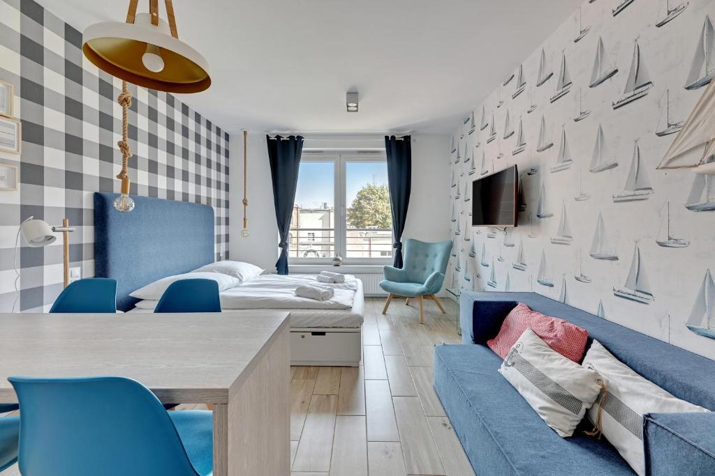 a room with a bed and a table and chairs at Grand Apartments - Tartaczna Sailor Studio Gdańsk in Gdańsk