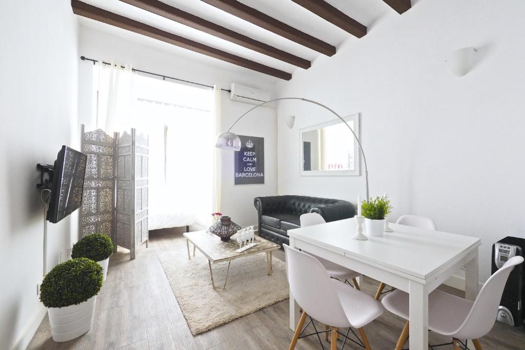 a white dining room with a white table and chairs at The White Flats Sant Antoni in Barcelona