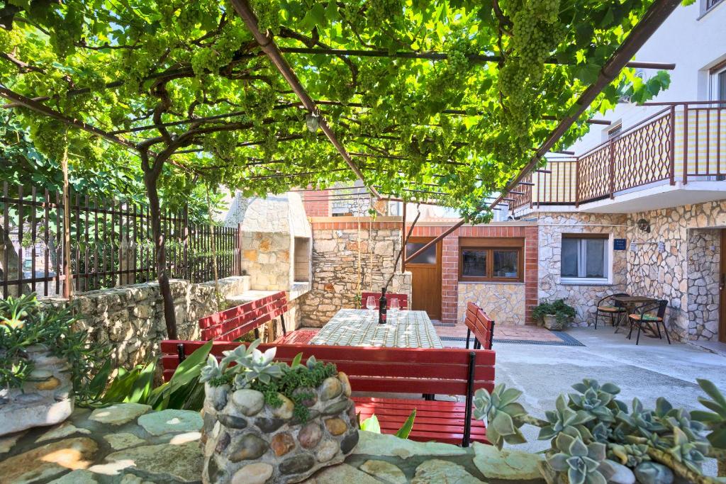 un patio con 2 bancos rojos y una mesa en Apartment Donata, en Premantura
