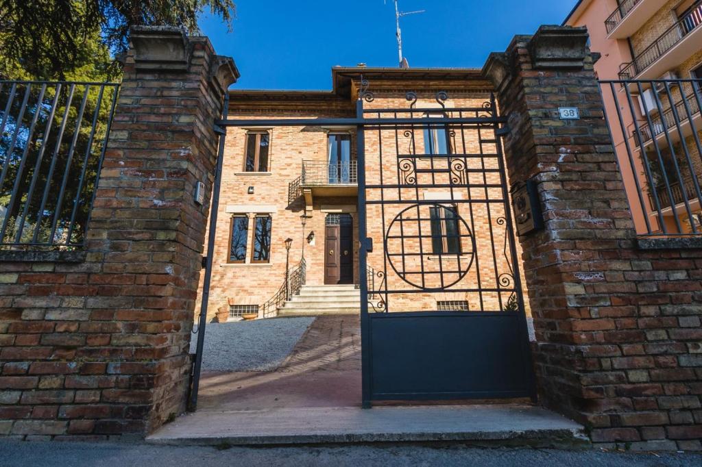 een ingang naar een bakstenen gebouw met een poort bij Hortensia Garden in Macerata