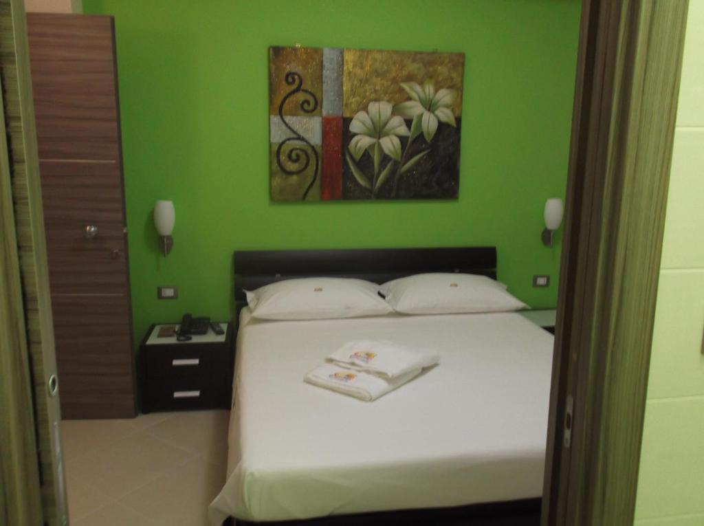 sypialnia z łóżkiem i zieloną ścianą w obiekcie Suliccenti b&b Marzamemi w mieście Marzamemi
