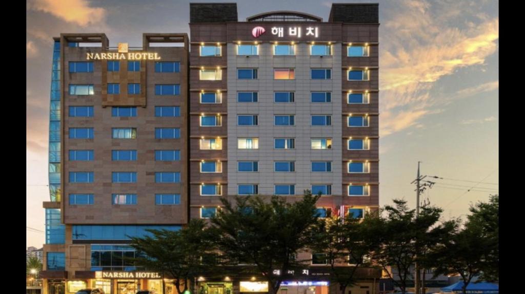 麗水的住宿－Yeosu Beach Hotel，一座高大的建筑,上面有标志