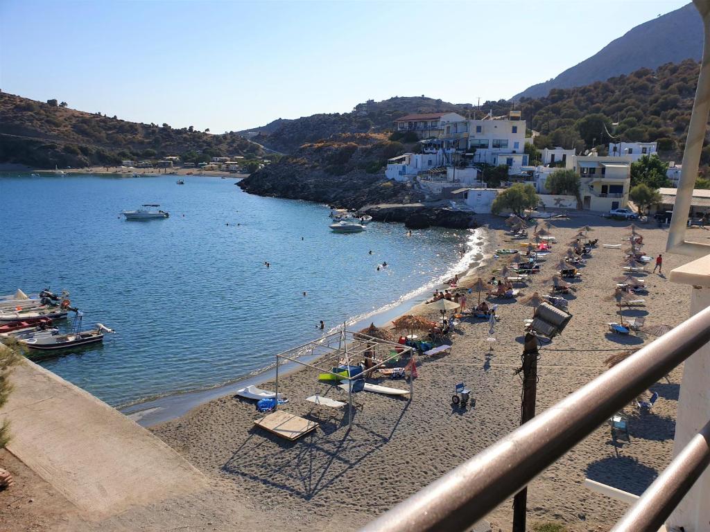 a beach with a bunch of chairs and people on it at The eagle in Kali Limenes