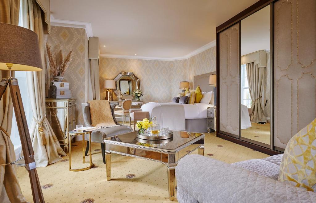 una sala de estar con una suite de hotel con un dormitorio en Hayfield Manor, en Cork