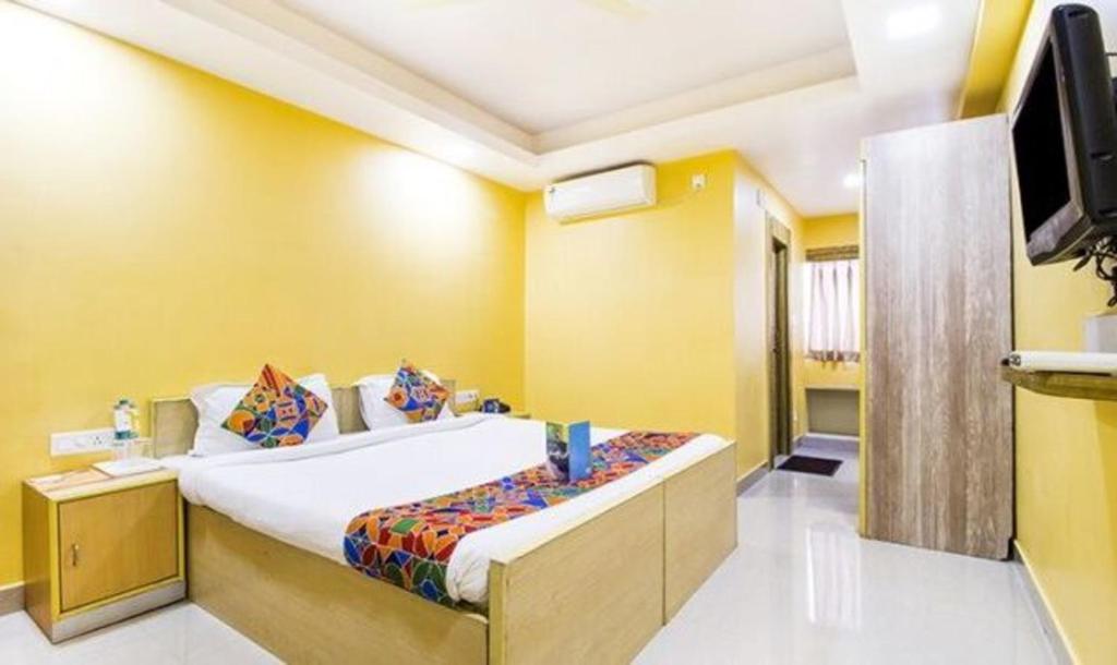 a bedroom with a large bed and a television at FabHotel Amaltas in Rānchī