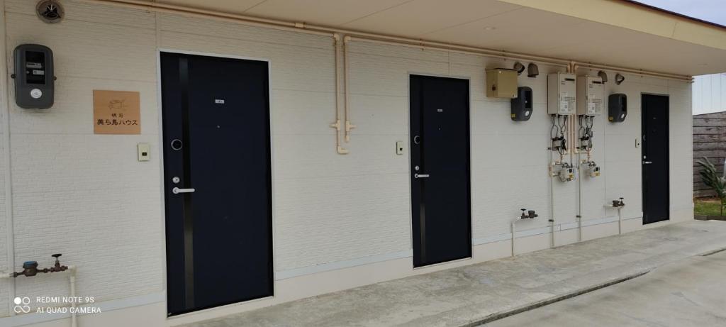 eine Reihe von Türen an der Seite eines Gebäudes in der Unterkunft 明石　美ら馬ハウス in Ishigaki-jima