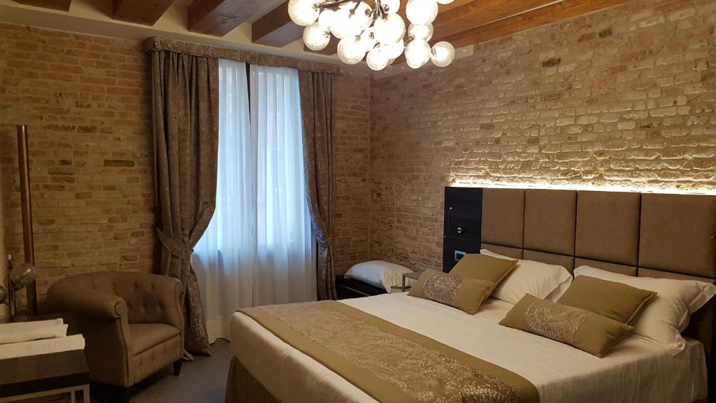 a bedroom with a large bed and a brick wall at Hotel Aquarius Venice - Ascend Collection in Venice