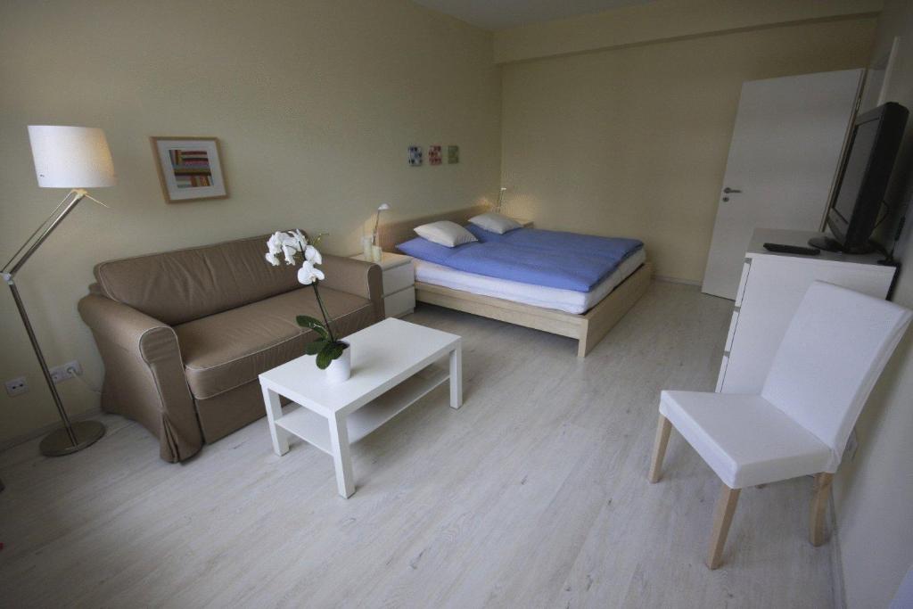 a living room with a bed and a couch and a table at City Lodging Apartments in Berlin