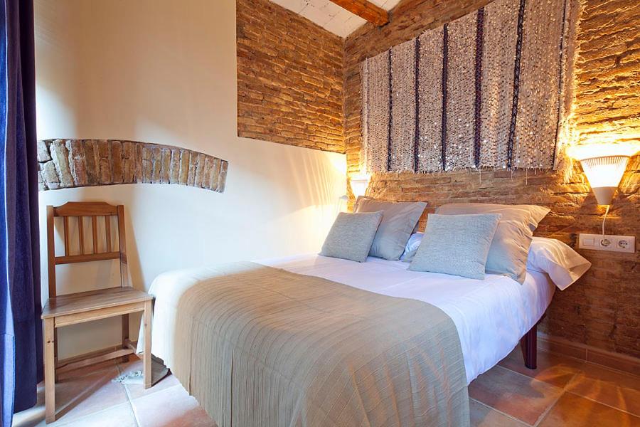 a bedroom with a white bed with two blue pillows at Friendly Rentals Santa Monica in Barcelona