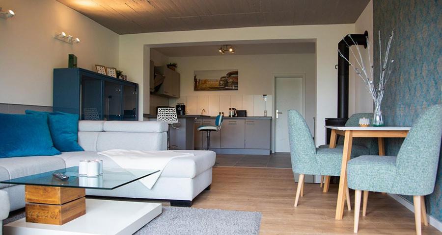 ein Wohnzimmer mit einem weißen Sofa, einem Tisch und Stühlen in der Unterkunft Meisterhaus Apartments in Glauchau
