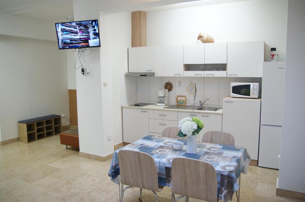 a kitchen with a table with a vase of flowers on it at APARTMAN IVANA in Pula