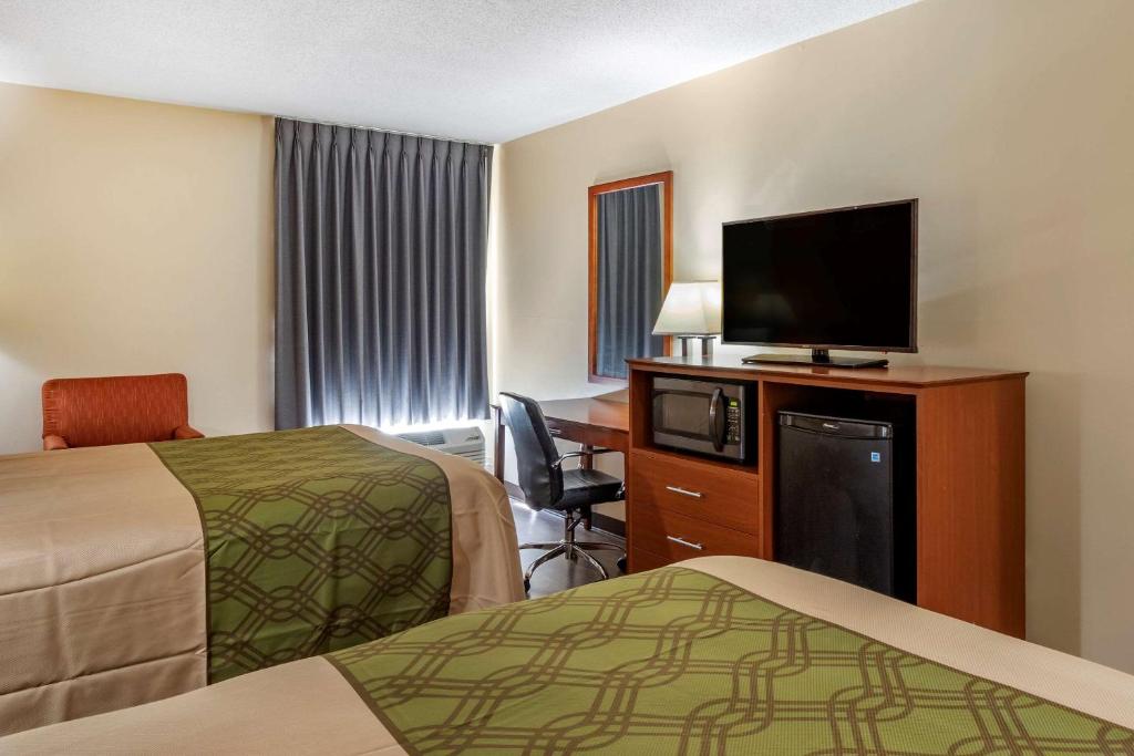 a hotel room with two beds and a flat screen tv at Econo Lodge in Saint Stephen