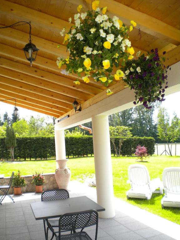 a pergola with a table and chairs and flowers at La Tieda - locazione turistica Reolon in Belluno