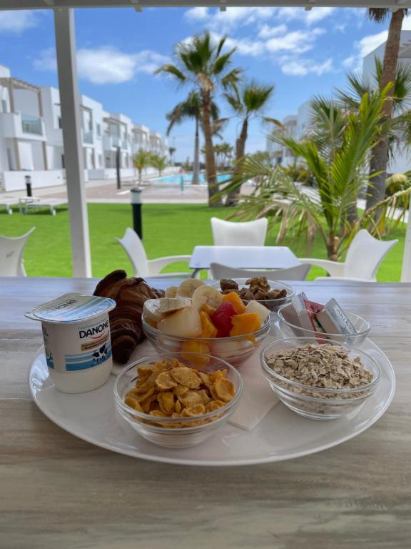 a plate with different types of food on a table at Island Home Fuerteventura in Corralejo