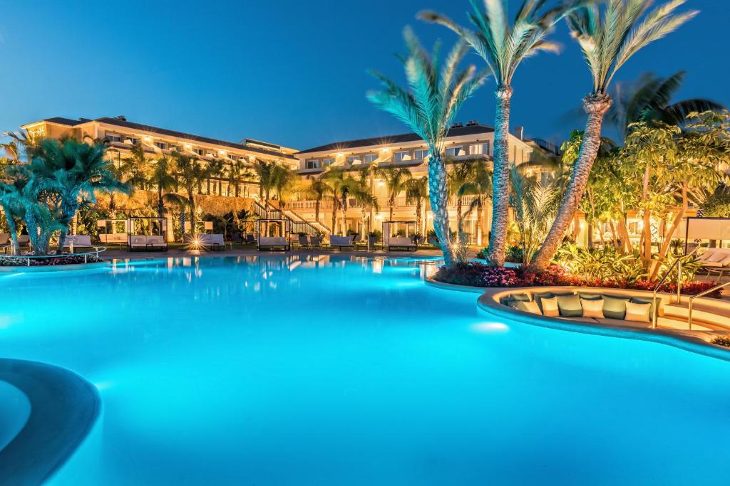 una gran piscina con palmeras frente a un edificio en Barceló La Nucía Palms, en La Nucía