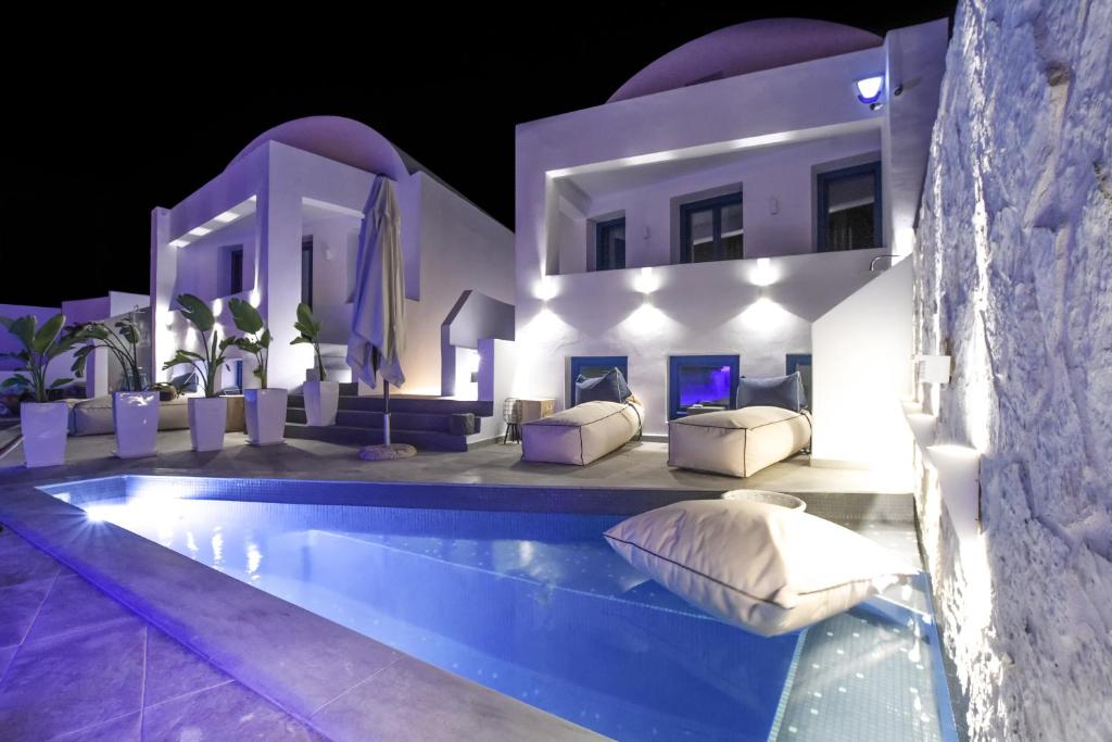 a villa with a swimming pool at night at Blue White Residence in Monolithos