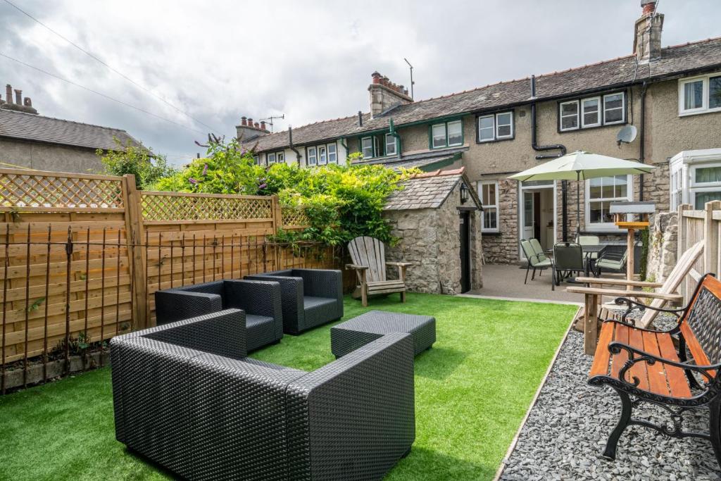 a garden with black furniture and green grass at Otter View in Kendal