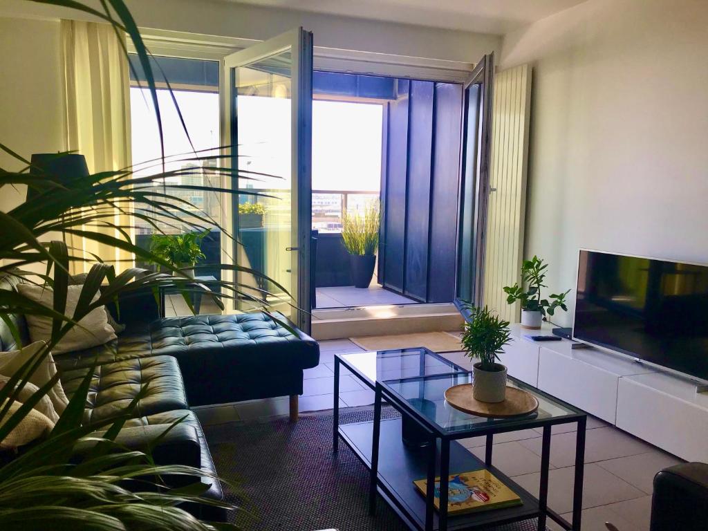 een woonkamer met een bank en een tv bij Appartement Cousteau - Terras, Zeezicht, Marina in Oostende
