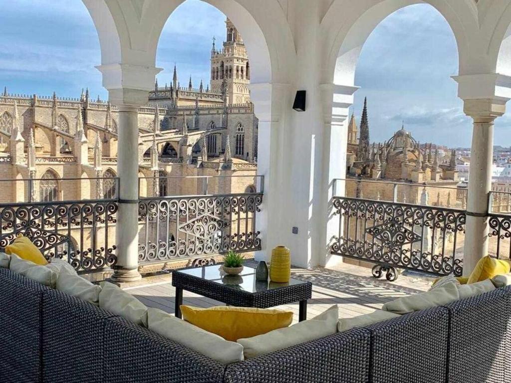 d'un balcon avec un canapé et une vue sur un bâtiment. dans l'établissement The most Exclusive apartment in Sevillaparking, à Séville
