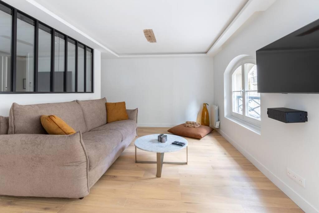 uma sala de estar com um sofá e uma mesa em HSH Invalides-Palais Bourbon Luxueux Appartement 4P em Paris