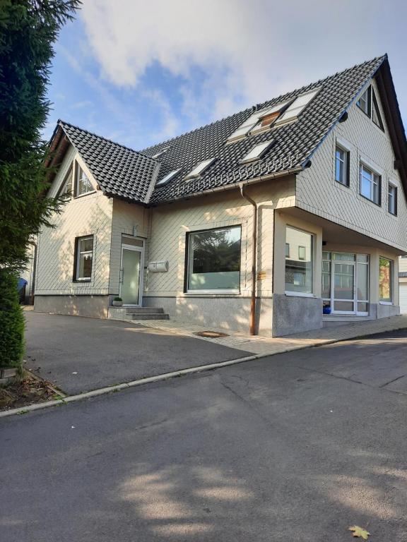 a house with a gray roof on a street at Ferienwohnung Grunwald in Oberhof