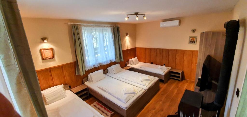 Habitación con 2 camas y ventana en Kis-Tisza Apartmanházak Tokaj- hegyalja en Tiszaladány