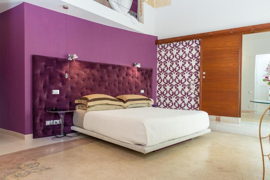 a bedroom with a large bed and purple walls at Monteforte Resort in Ugento