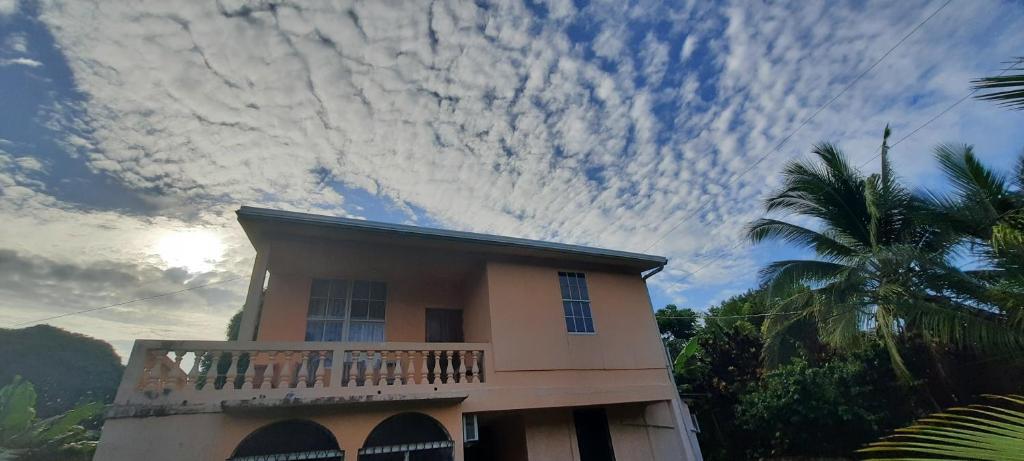 Casa con balcón y cielo nublado en Hospedaje Tropical Dreams, en Corn Island