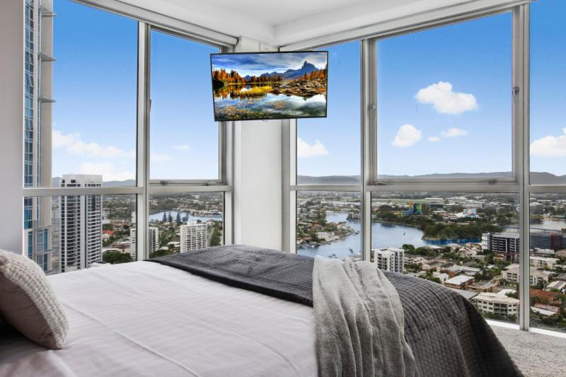 a bedroom with a large window with a tv above a bed at Chevron Renaissance 2 Bed Apartment by Vaun in Gold Coast