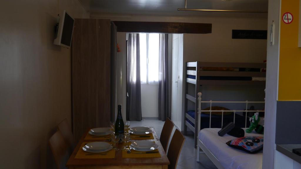 een kleine kamer met een tafel en een bed bij Residence Alassa in Montévrain