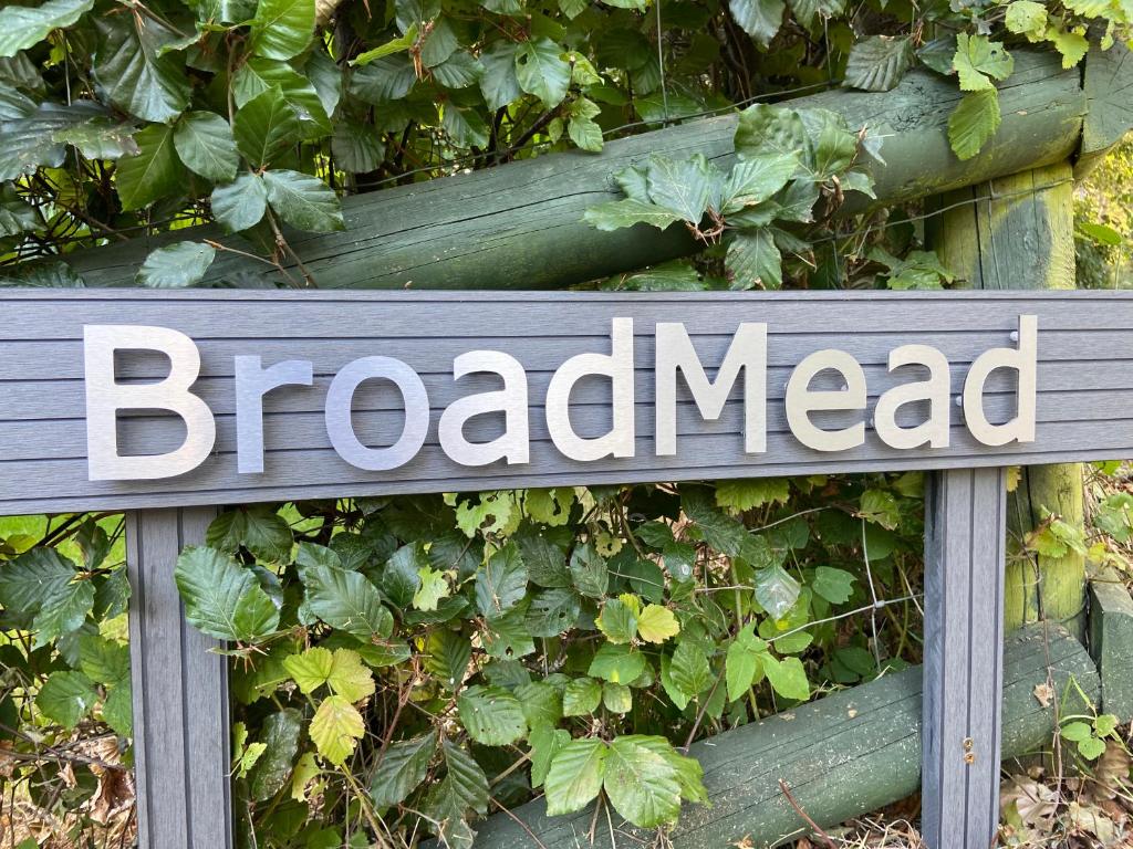 a sign that reads broadaced in front of a bush at Broad Mead in Corfe Castle