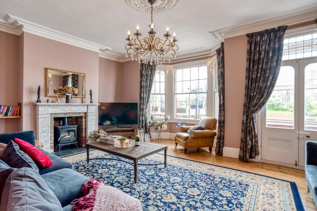 a living room with a blue couch and a fireplace at The Beach House - Cromer in Cromer