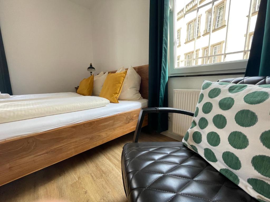 Habitación con cama, silla y ventana en BrauHotel Bonn en Bonn