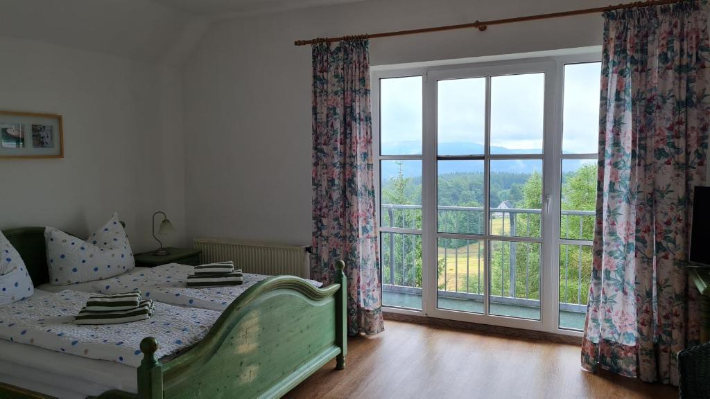 a bedroom with a bed and a large window at Pension Breitenborn in Masserberg