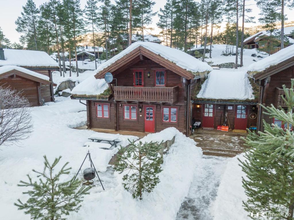 une cabane en rondins dans la neige avec de la neige au sol dans l'établissement Vrådal Panorama - Tiuråsvegen 39, à Vradal