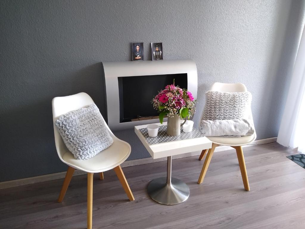 a room with two chairs and a table with a tv at Apartment 358 mit Sauna, Schwimmbad und Fitness in Schonwald im Schwarzwald