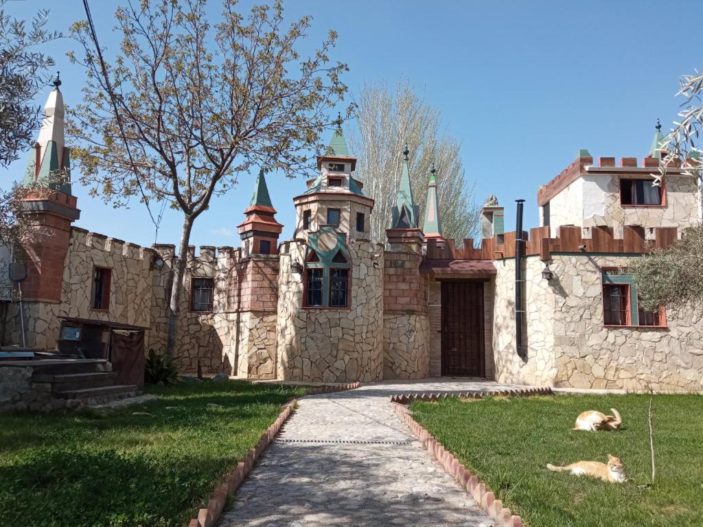 un viejo castillo con un perro tirado en la hierba en Castillo Esmeralda en Las Gabias